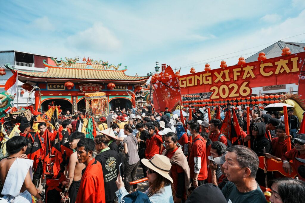 Vibrant Chinese New Year festival celebrations at a temple in Singkawang, Indonesia, with a lively crowd and festive decorations.