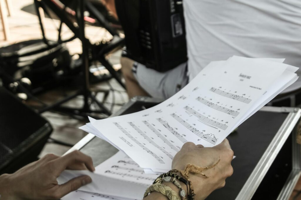 Close-up of musician's hands with sheet music during a rehearsal in a studio setting.
