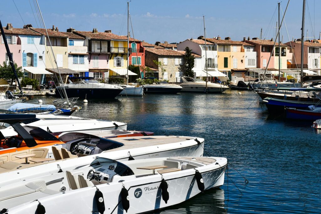 Scenic view of Port Grimaud marina with vibrant houses and luxury boats on a sunny day.
