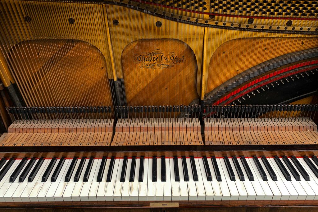 Detailed view of Chappell & Co. grand piano keys and strings inside an acoustic piano.