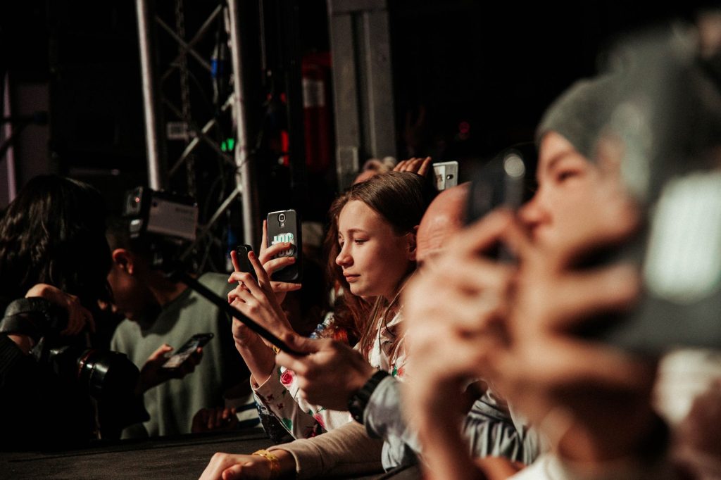 Fans filmant un concert avec leur téléphone