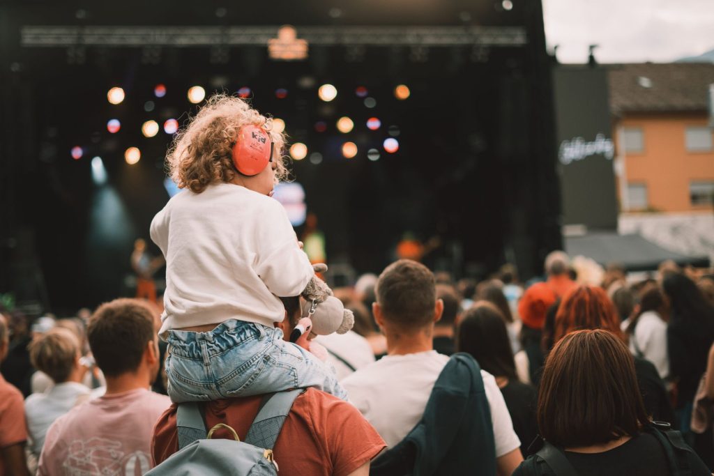 Enfant avec casque anti-bruit dans la foule d'un festival