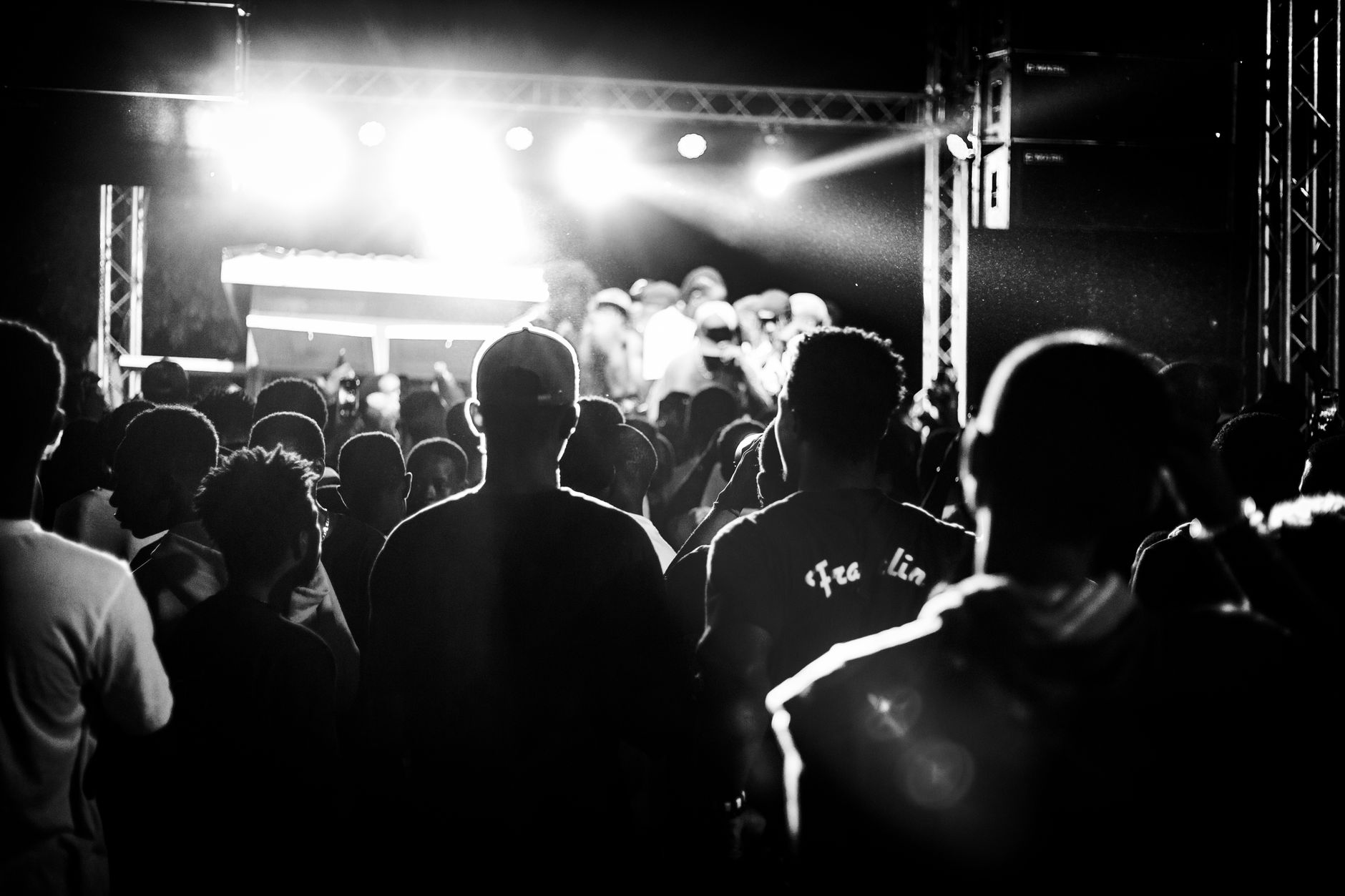 Foule en noir et blanc devant la scène éclairée