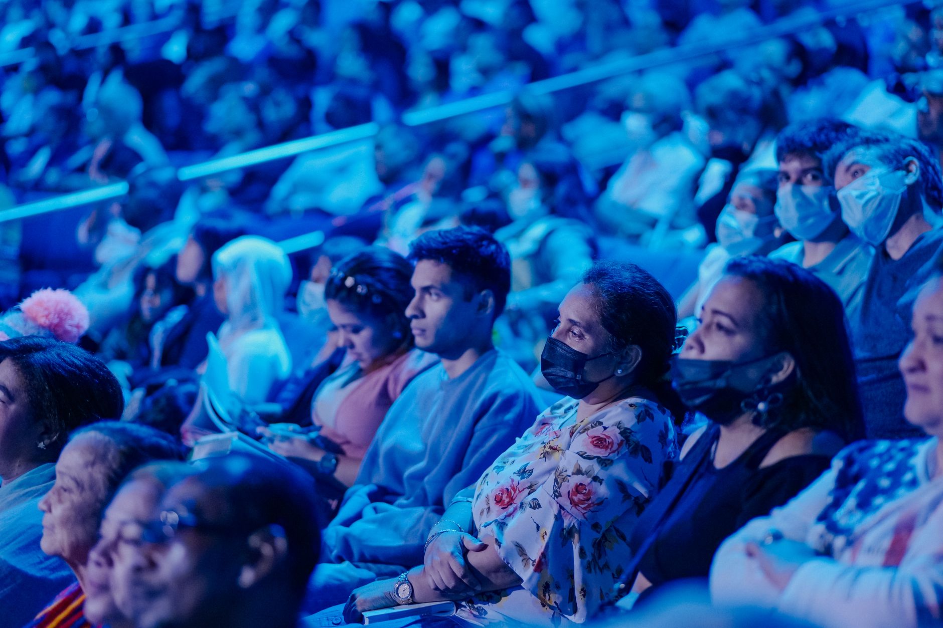 Public assis éclairé en bleu dans une salle