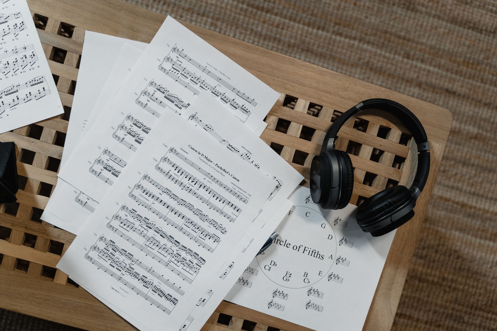partitions de musique étalées sur une table en bois à côté d'un casque audio