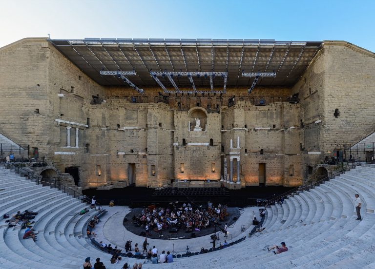 Le mur de scène du Théâtre antique d'Orange et ses gradins, orchestre en répétition pour les Chorégies