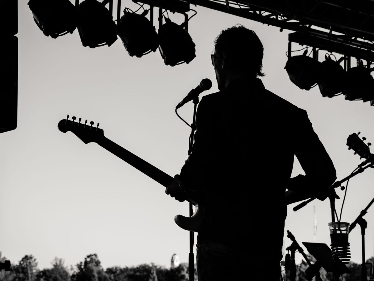 Guitariste en silhouette sur scène extérieure