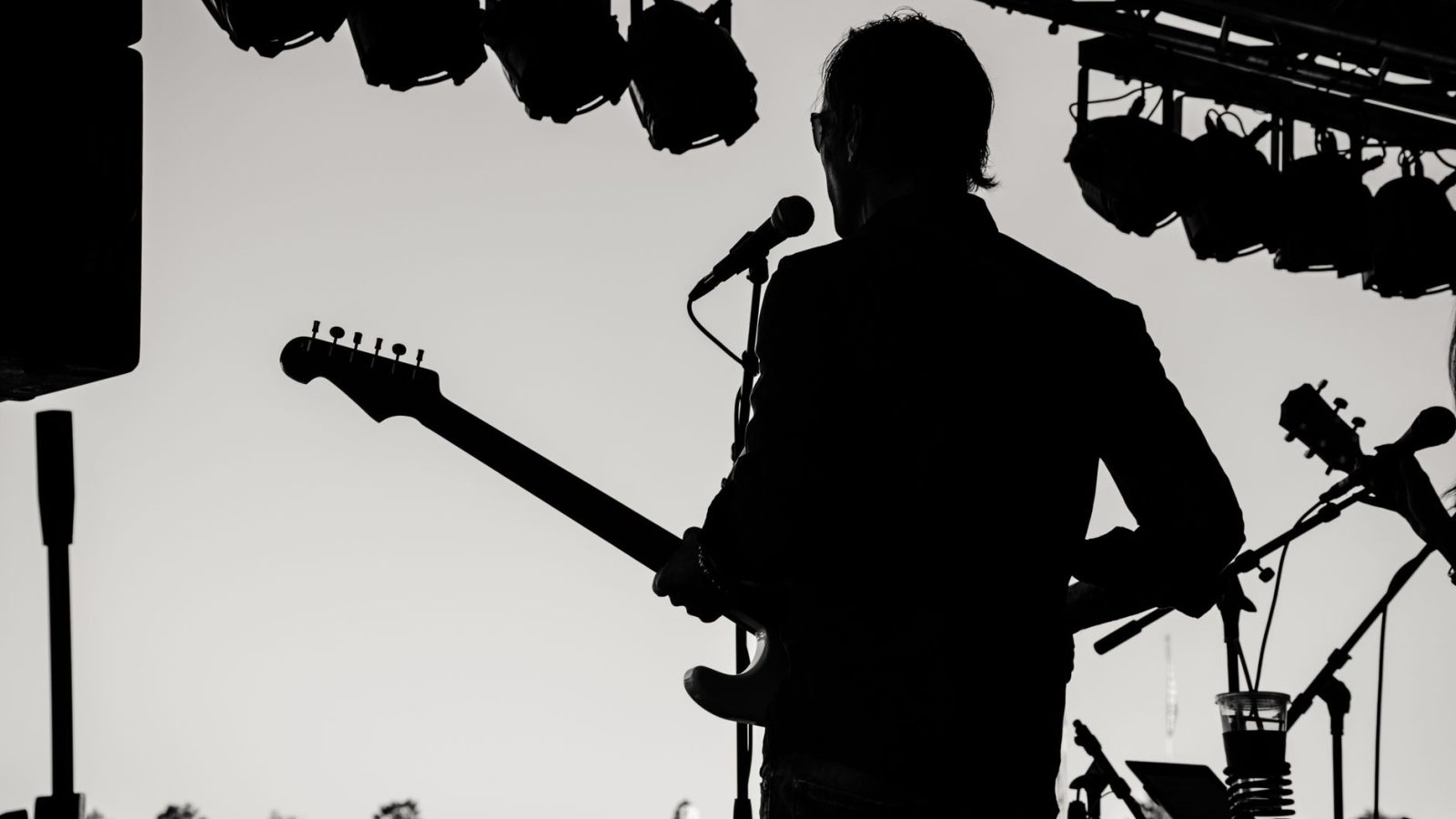 Guitariste en silhouette sur scène extérieure