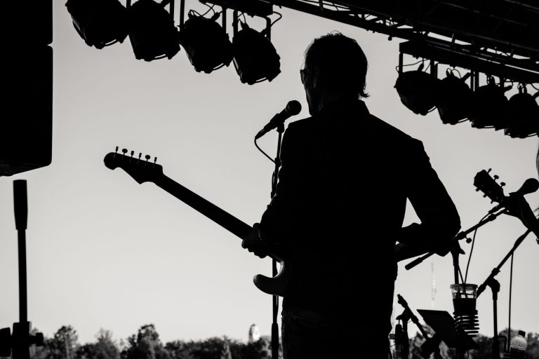 Guitariste en silhouette sur scène extérieure