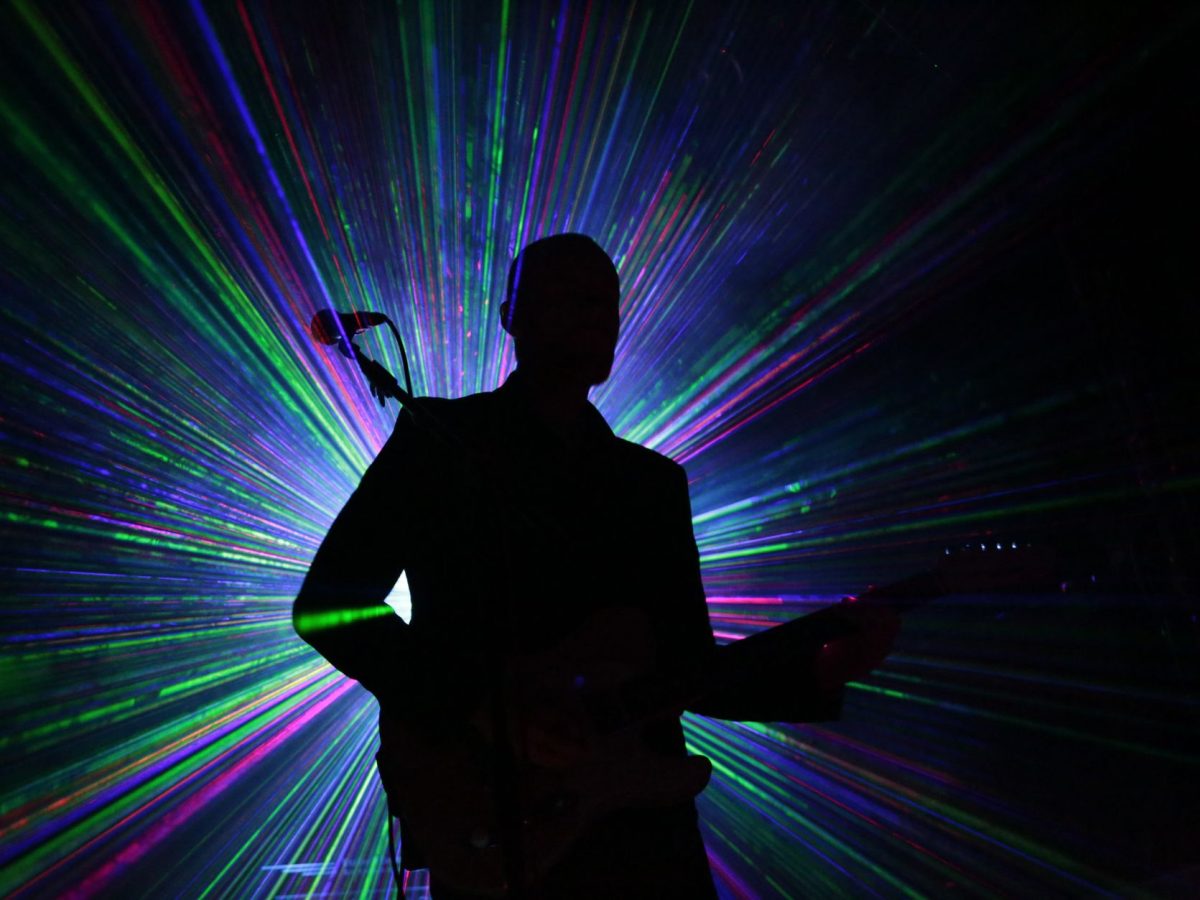 Guitariste en silhouette sous lasers colorés