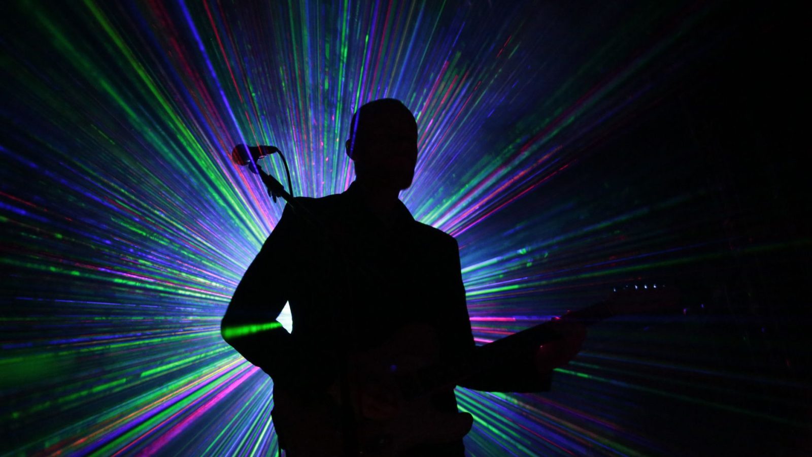 Guitariste en silhouette sous lasers colorés