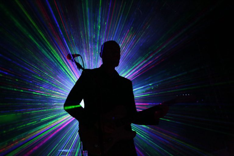 Guitariste en silhouette sous lasers colorés