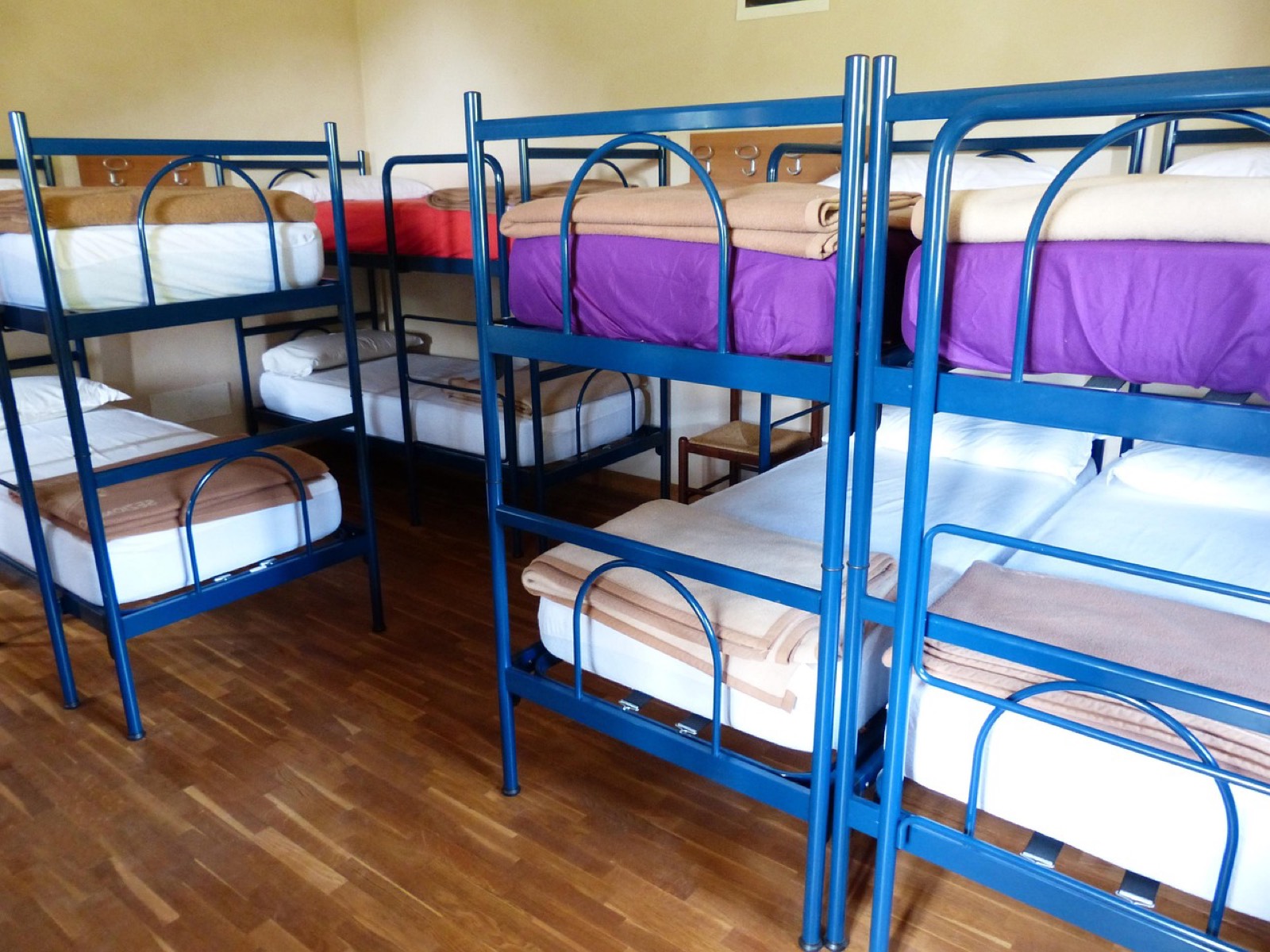 Choristes installés dans un gîte groupé avec sacs, partitions et pupitres