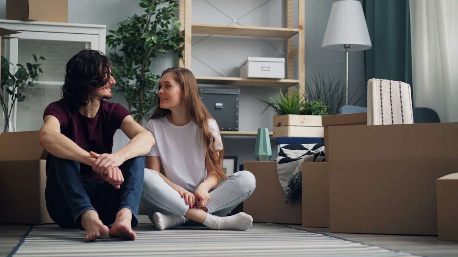 jeune femme avec clés et cartons de déménagement dans un appartement